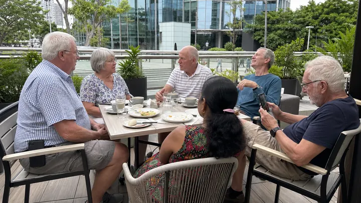 Older people having breakfast together at an outdoor café table