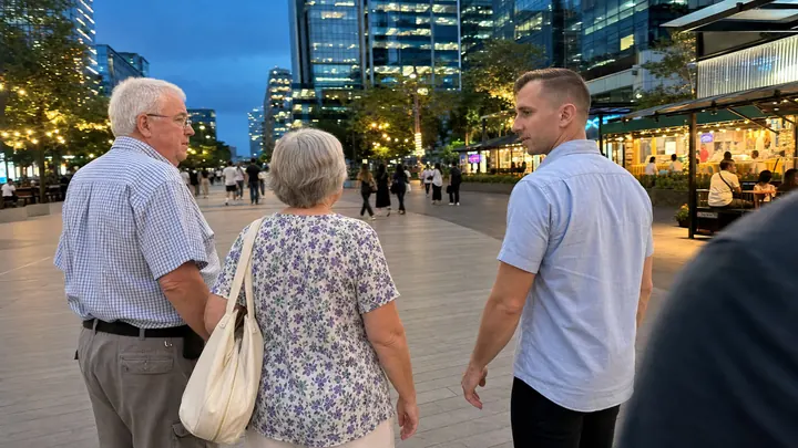 A couple walking through IT Park in the evening with a local guide